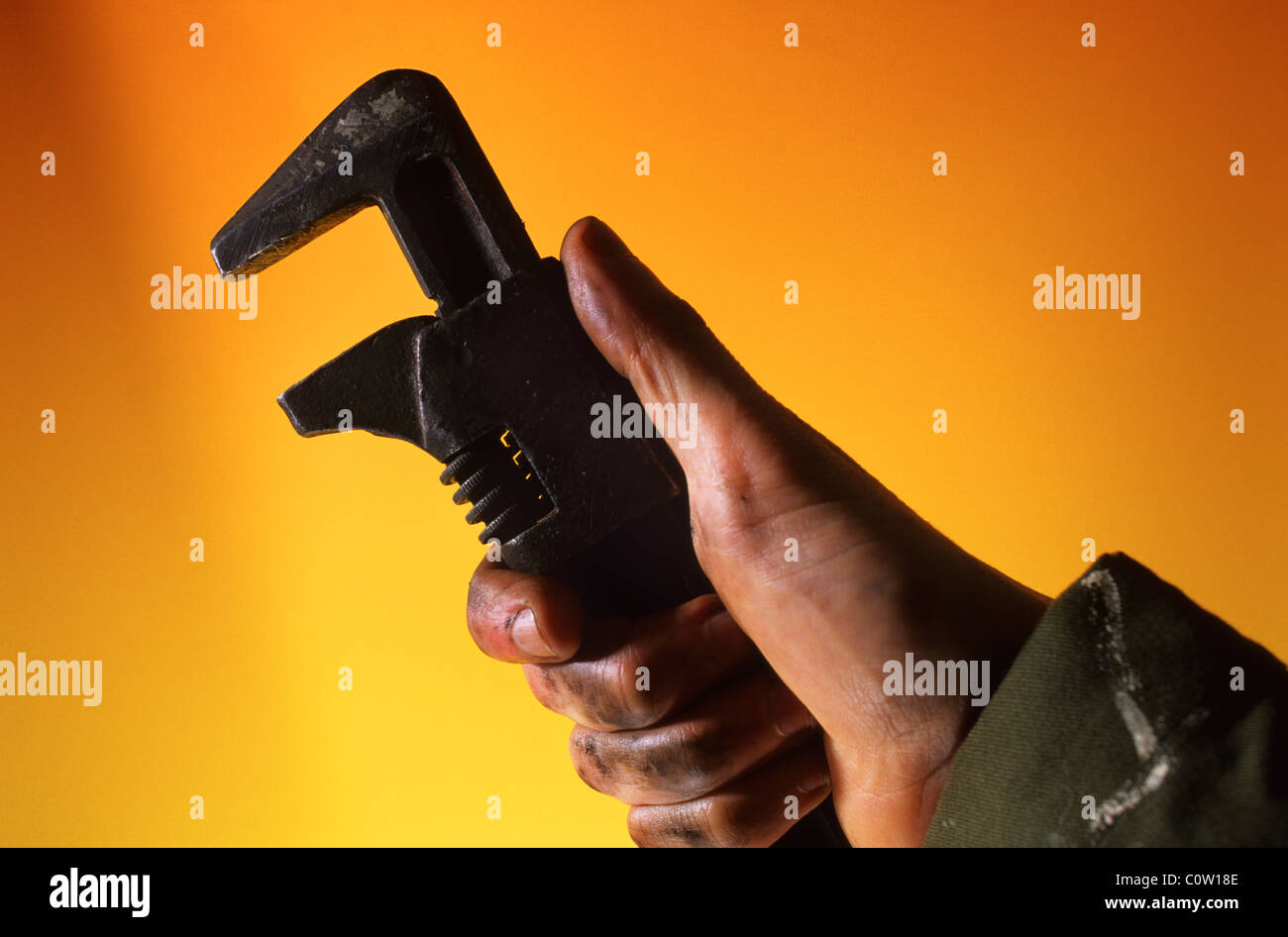 Meccanico con mano oleoso tenendo la chiave regolabile Foto Stock