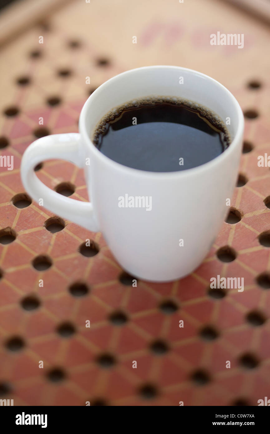 Caffè in tazza bianca sul bordo del gioco Foto Stock