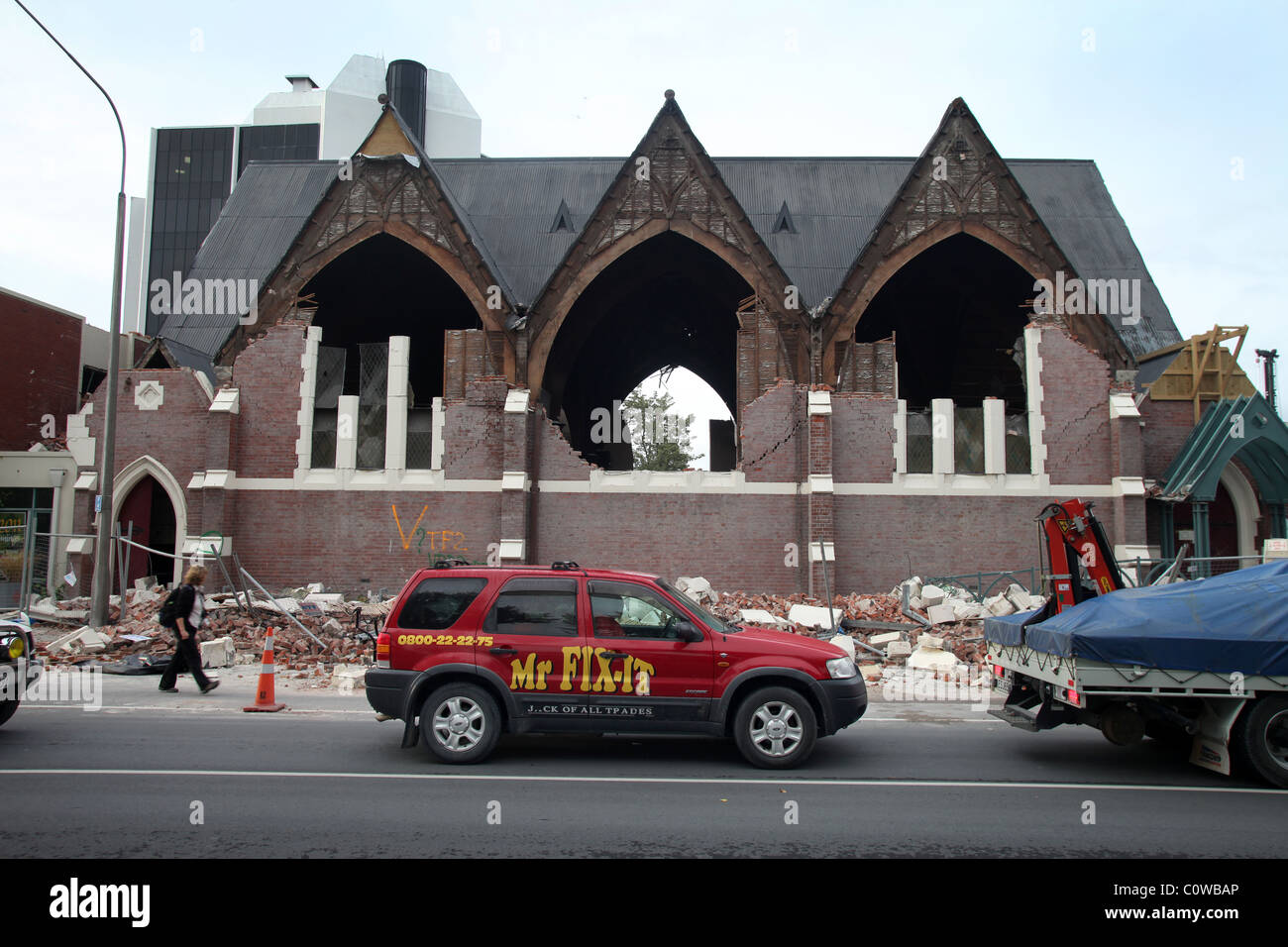 Tuttofare l'auto di fronte la chiesa in rovina a Christchurch, Nuova Zelanda, dopo il 6.3 terremoto di magnitudine Foto Stock