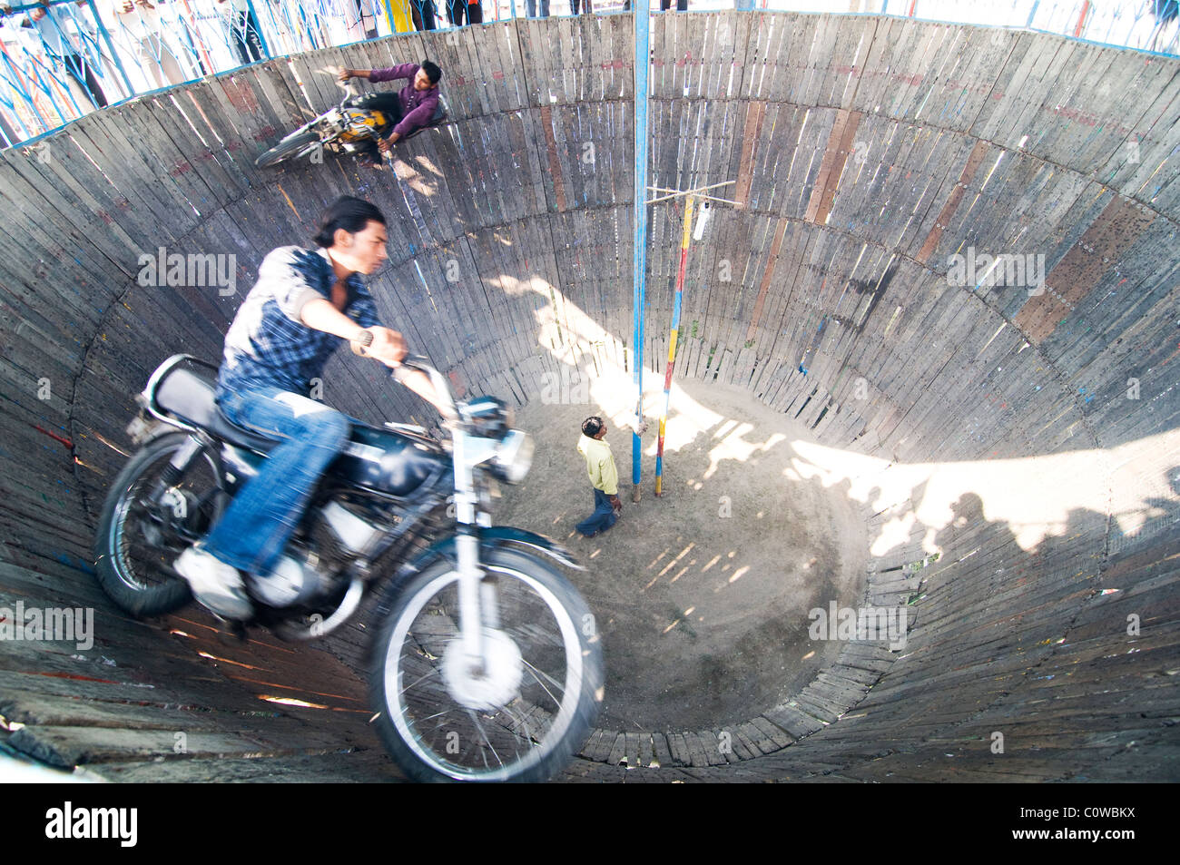 Bikers eseguono acrobazie in un circo rurale in India. Foto Stock