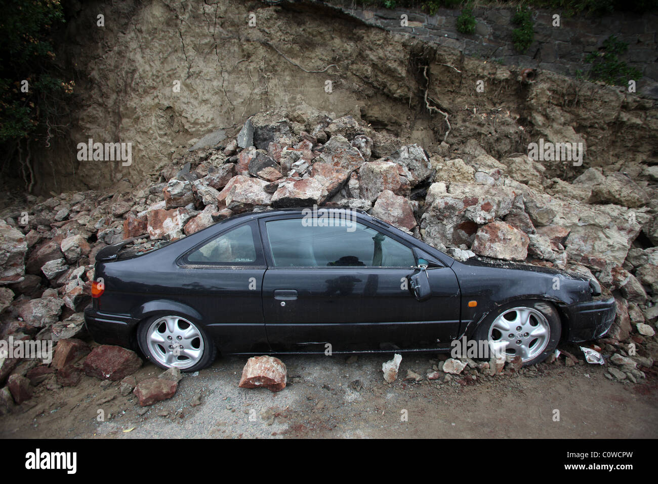 Auto sepolto in macerie da una scogliera in Sumner, Christchurch in Nuova Zelanda dopo il 6.3 terremoto di magnitudine Foto Stock