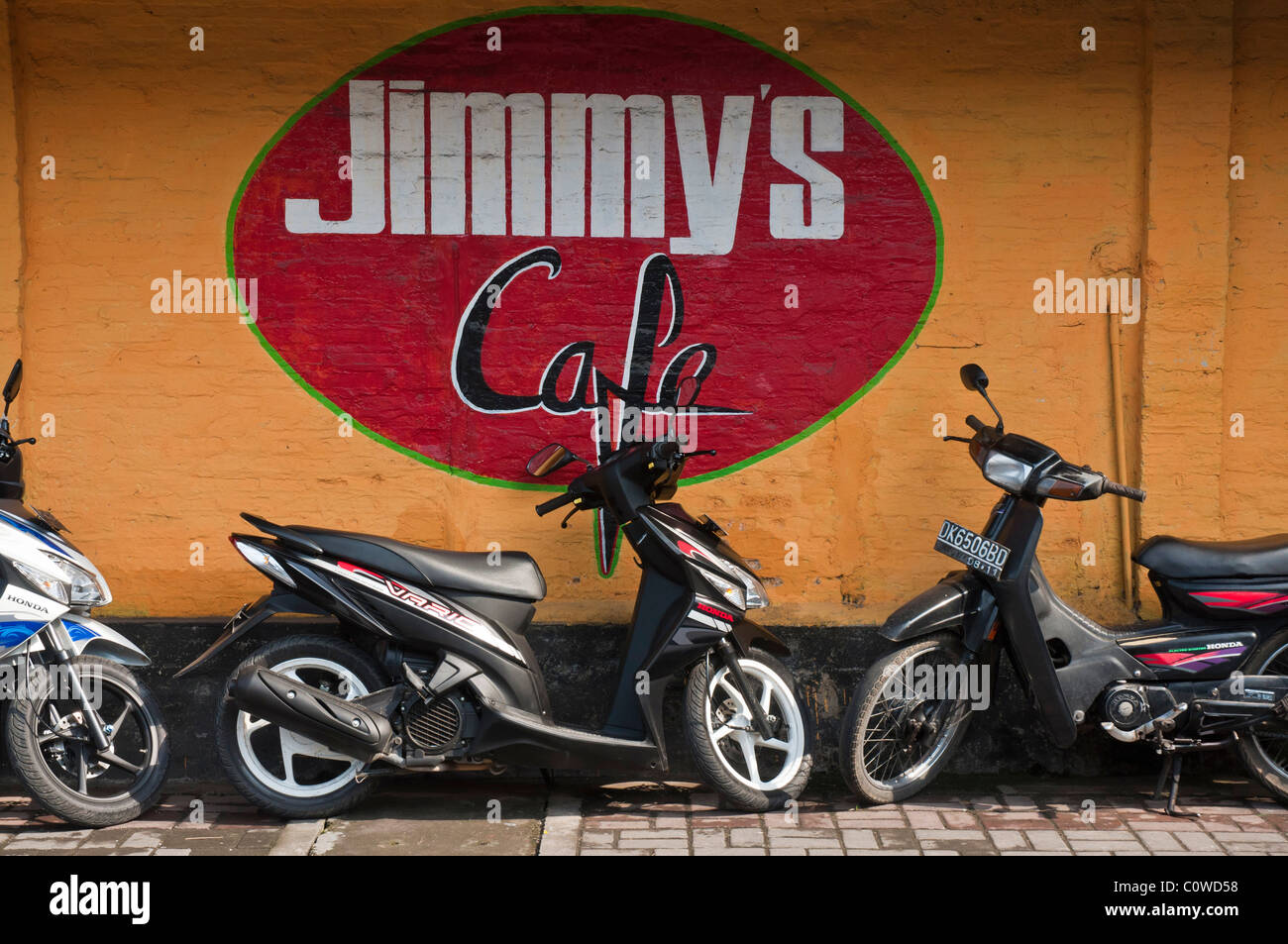 Scooters parcheggiato outiside ben noto bar Jimmy's Cafe in Sanur Bali Indonesia Foto Stock