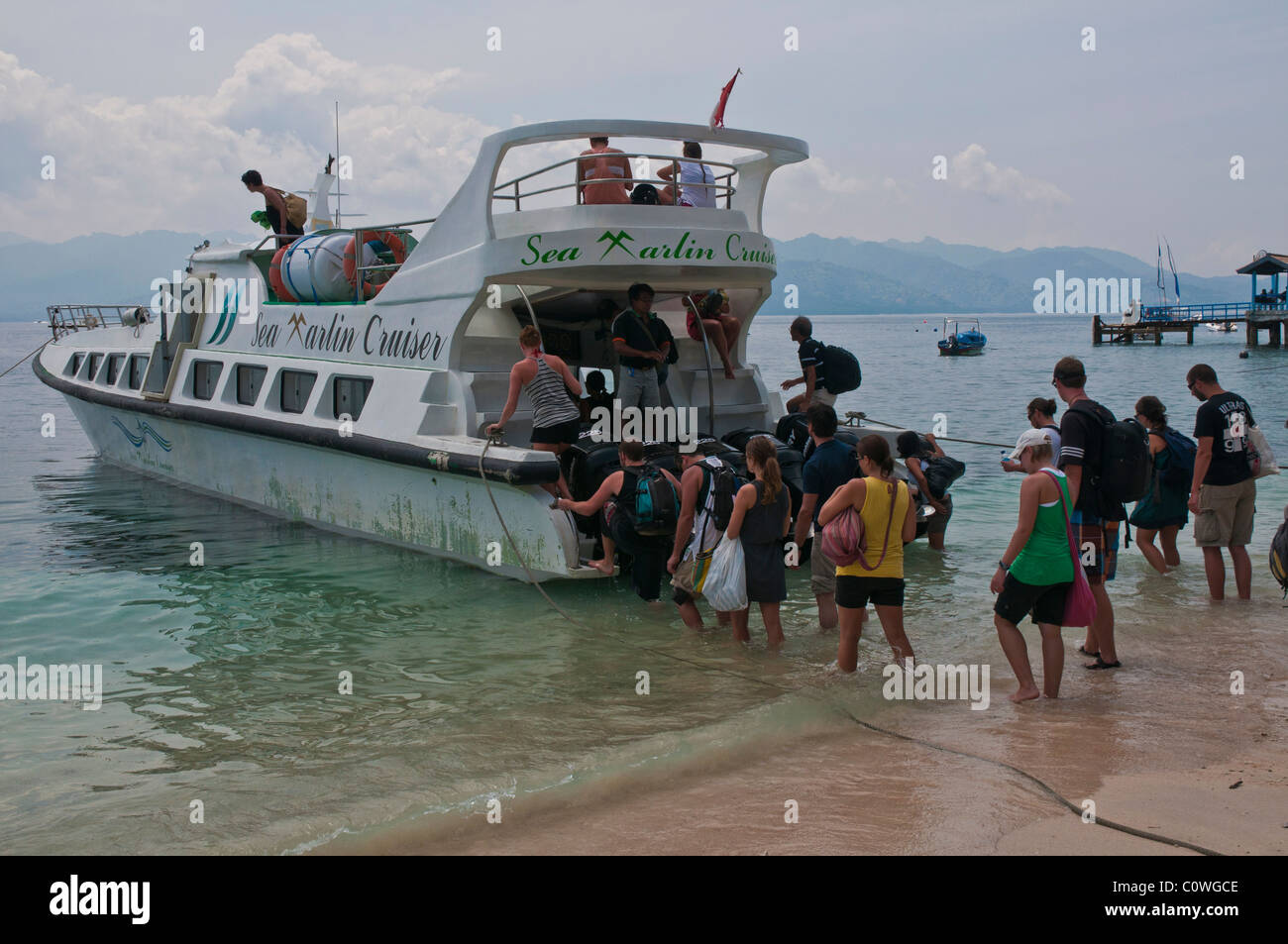 I turisti di salire a bordo di una delle alte velocità imbarcazioni a Gili Trawangan Lombok off per un'ora e mezza di viaggio a Bali Foto Stock