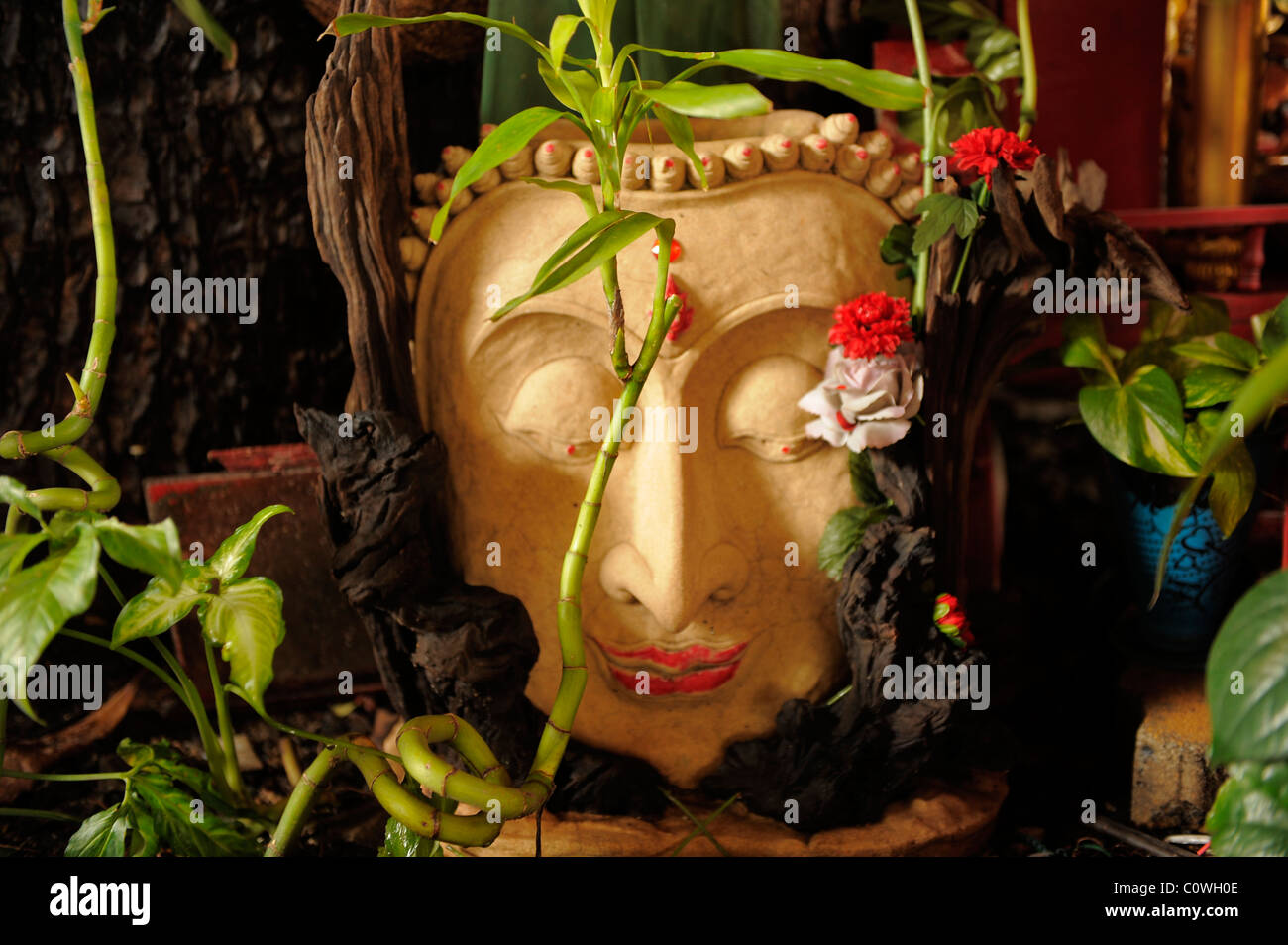 Il buddha immagine di pietra decorata con fiori , chinatown , bangkok, Thailandia Foto Stock