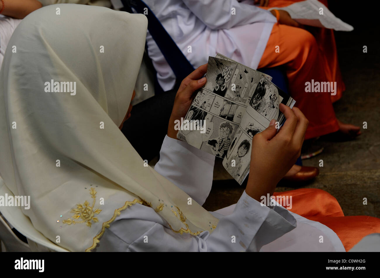Giovani Musulmani lettura della ragazza comico , scuola islamica, bangkok, Thailandia Foto Stock