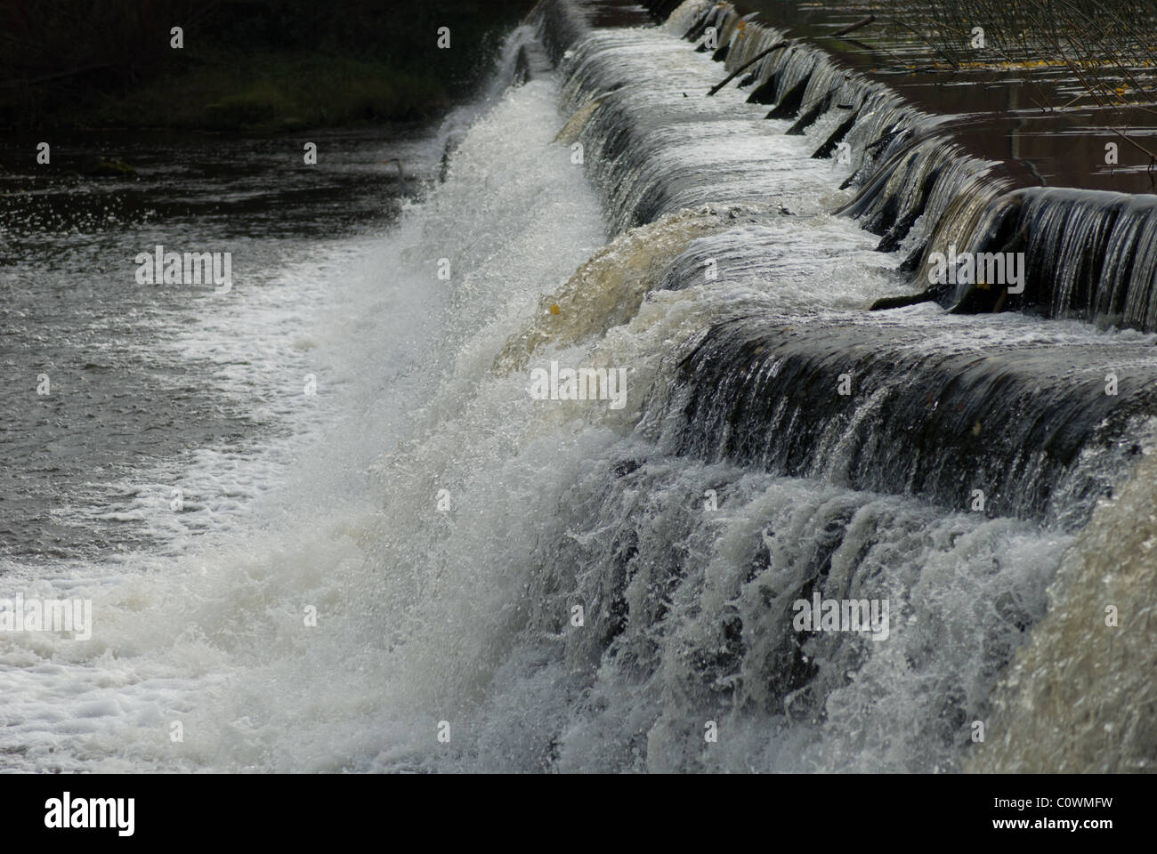 L'acqua che scorre su uno stramazzo in un fiume Foto Stock