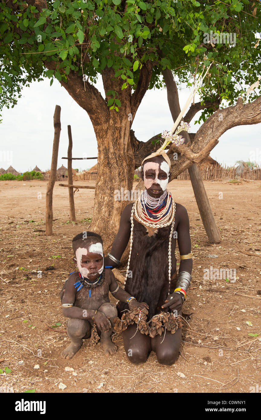 Karo donna con pitture facciali e colorati di collane e baby Omo river valley, sud Etiopia Foto Stock