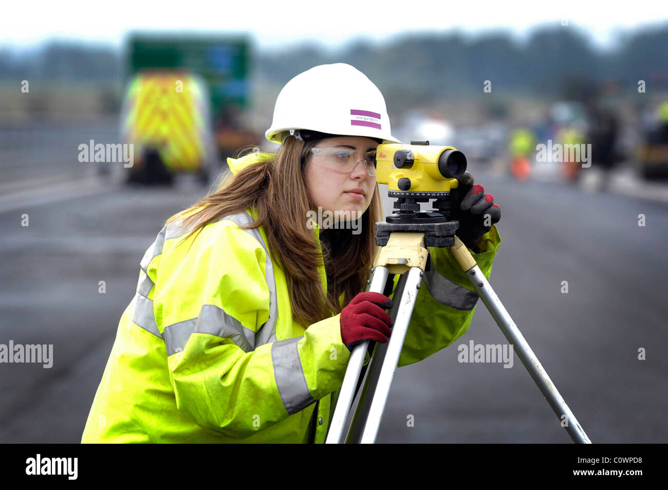 Donna geometra, ingegnere civile utilizzando un teodolite Foto Stock