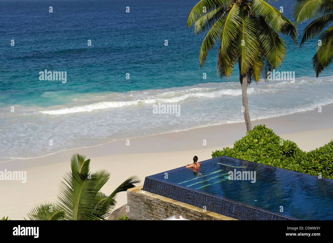Donna seduta nella piscina dell'Hotel Banyan Tree, Mahe Island, Seicelle Foto Stock