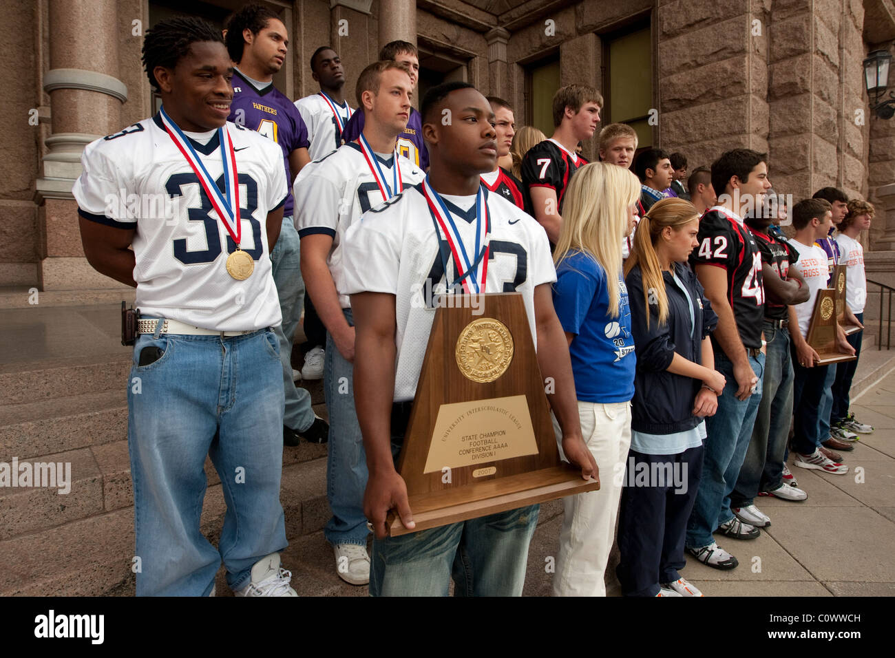 Maschio afro-americano mantiene uno stato campionato trofeo durante la cerimonia per il membro champs a varie attività sportive presso il Campidoglio del Texas Foto Stock