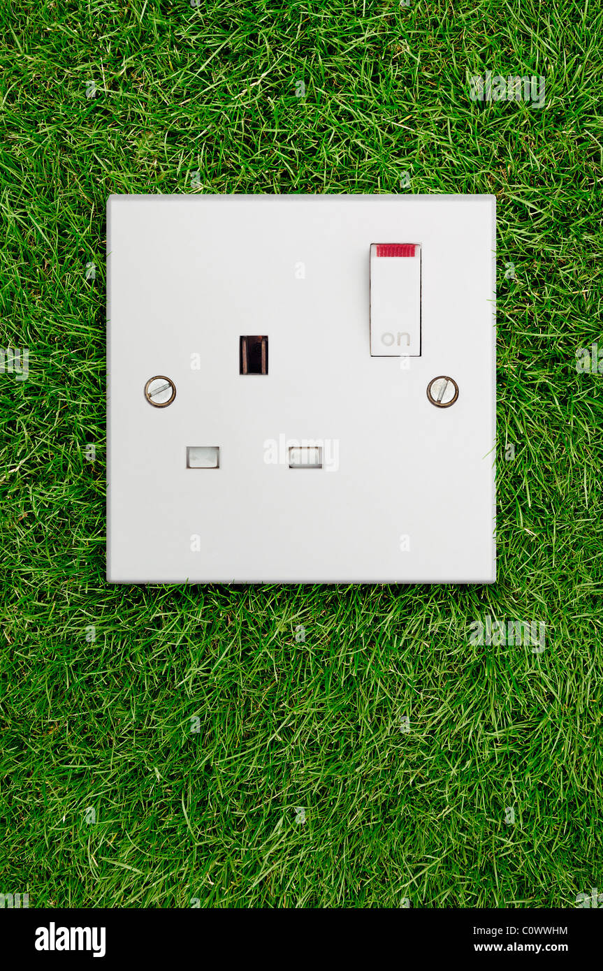Presa elettrica sull'erba. Energia verde concetto. Foto Stock