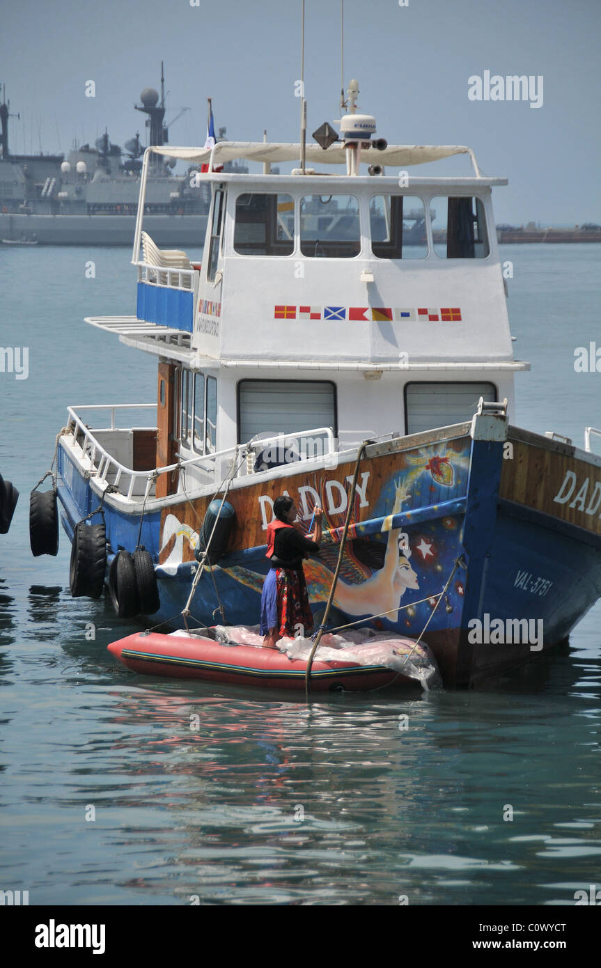 Donna dipinto il nome di una barca nel porto di Valparaiso Cile Foto Stock