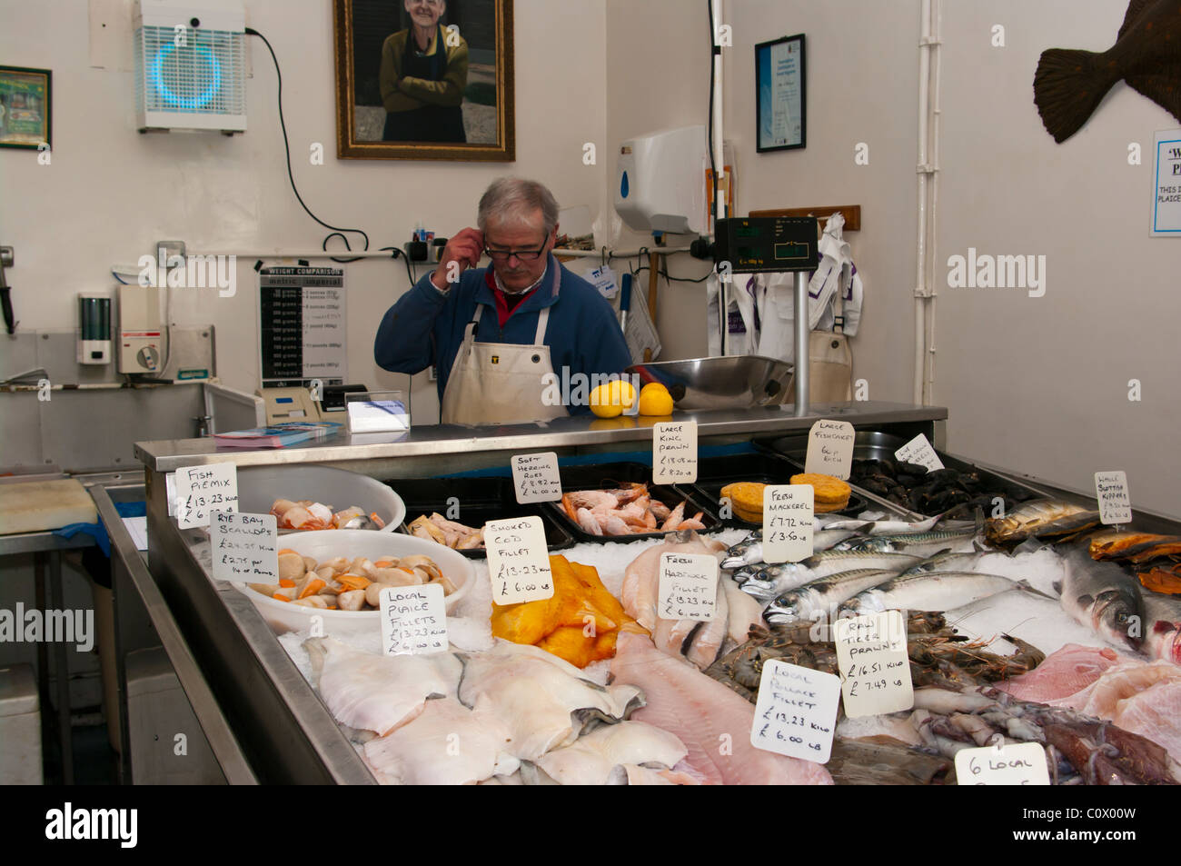Pescivendolo al suo contatore in una pescivendoli Foto Stock