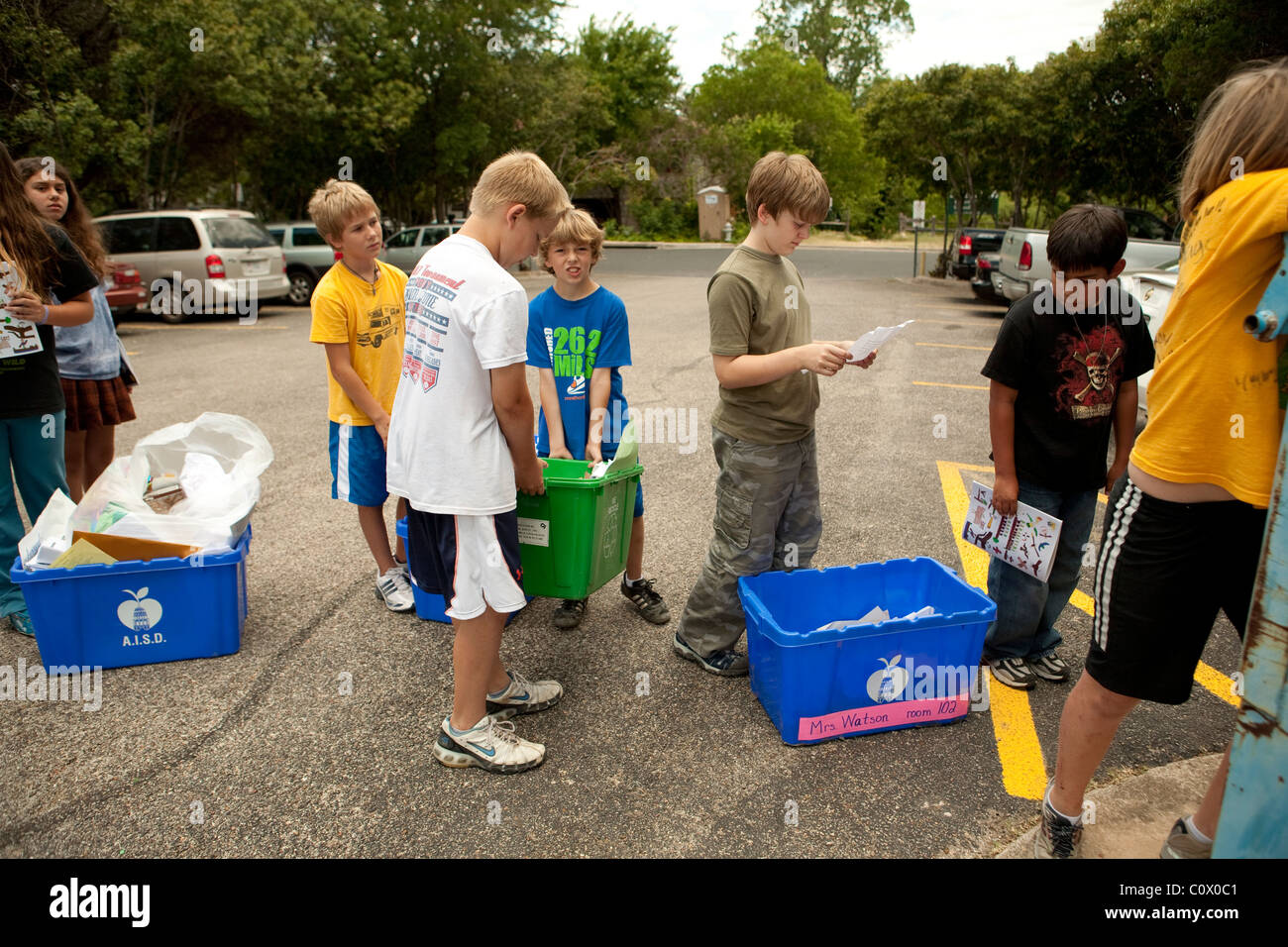 Il quinto anno gli studenti elementari portano alle carte a riciclare il cassonetto a scuola come hanno pulito le aule alla fine dell anno scolastico Foto Stock