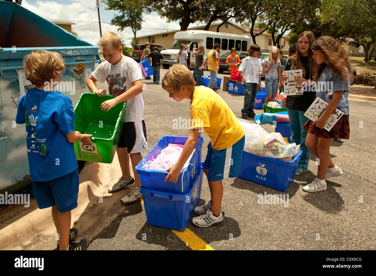 Il quinto anno gli studenti elementari portano alle carte a riciclare il cassonetto a scuola come hanno pulito le aule alla fine dell anno scolastico Foto Stock