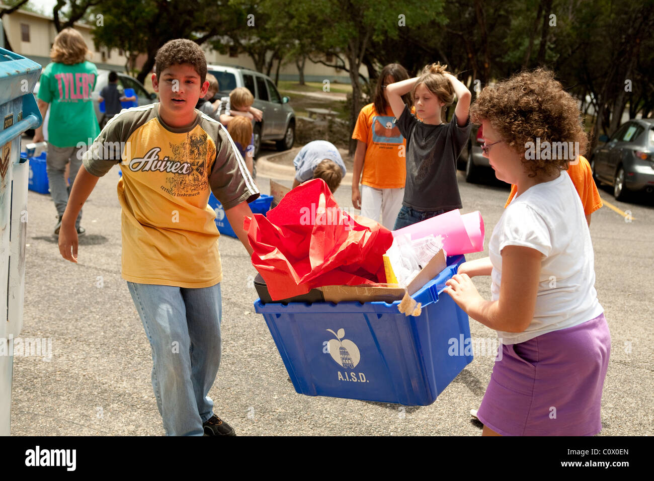 Il quinto anno gli studenti elementari portano alle carte a riciclare il cassonetto a scuola come hanno pulito le aule alla fine dell anno scolastico Foto Stock