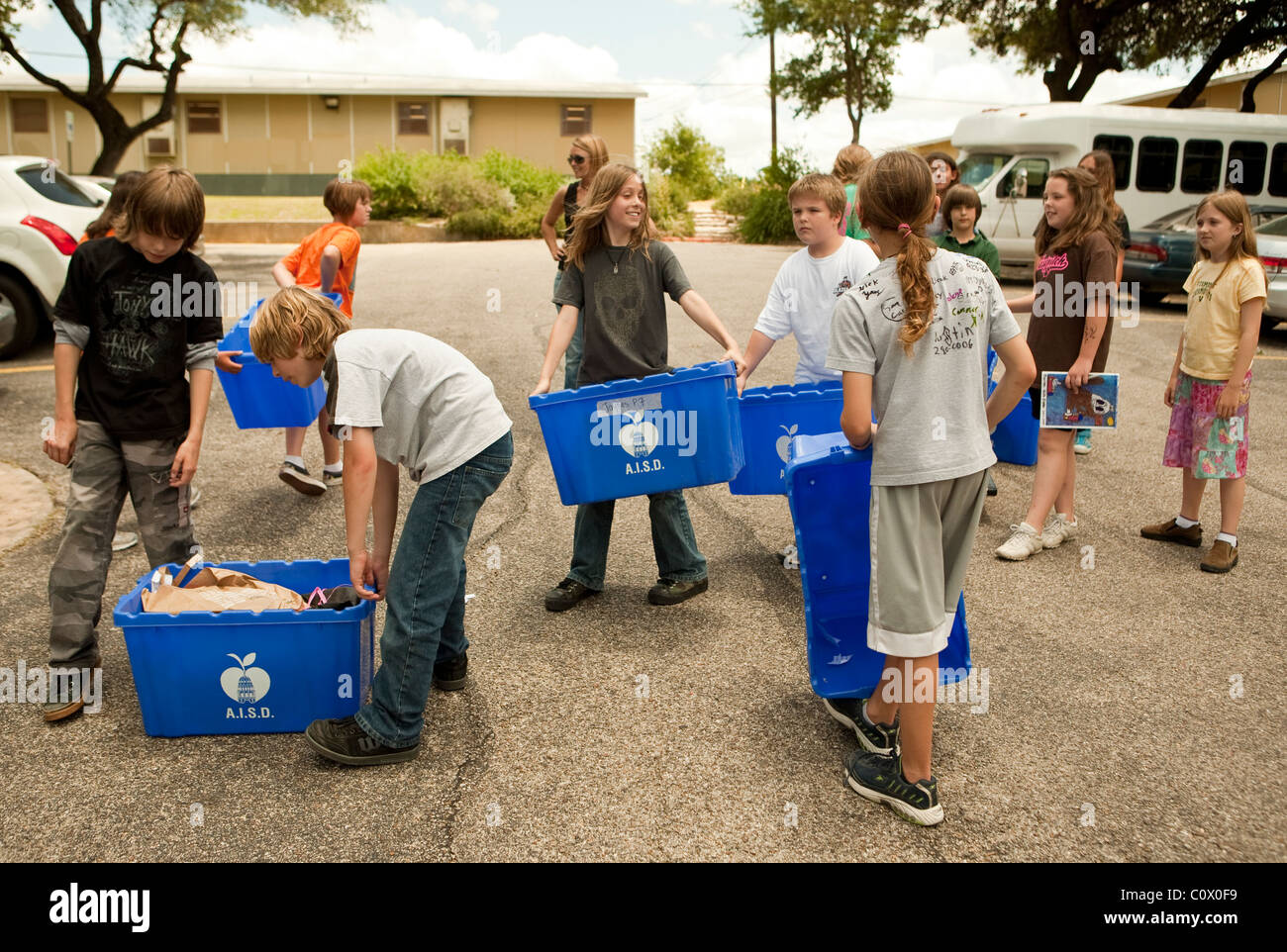 Il quinto anno gli studenti elementari portano alle carte a riciclare il cassonetto a scuola come hanno pulito le aule alla fine dell anno scolastico Foto Stock