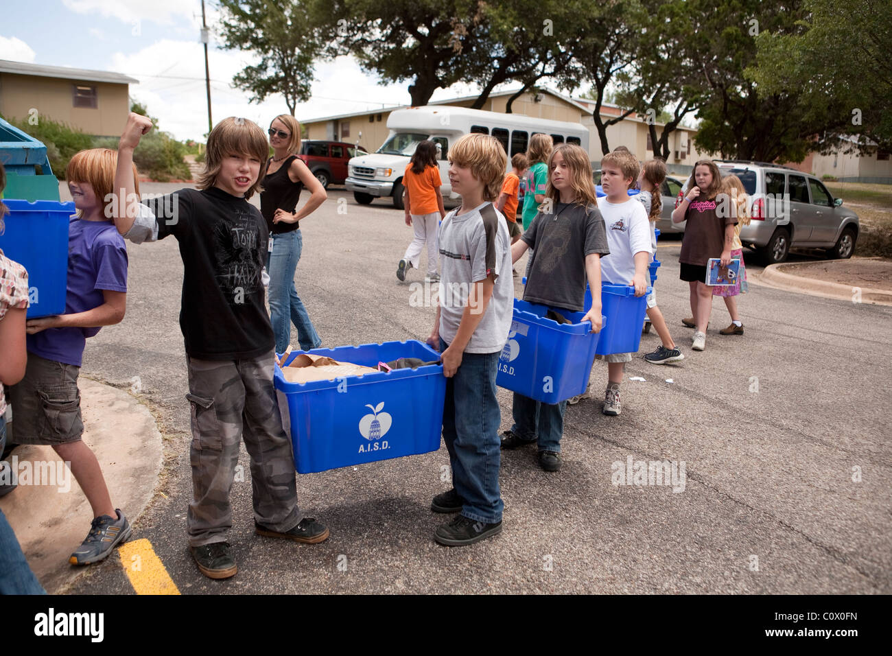 Il quinto anno gli studenti elementari portano alle carte a riciclare il cassonetto a scuola come hanno pulito le aule alla fine dell anno scolastico Foto Stock