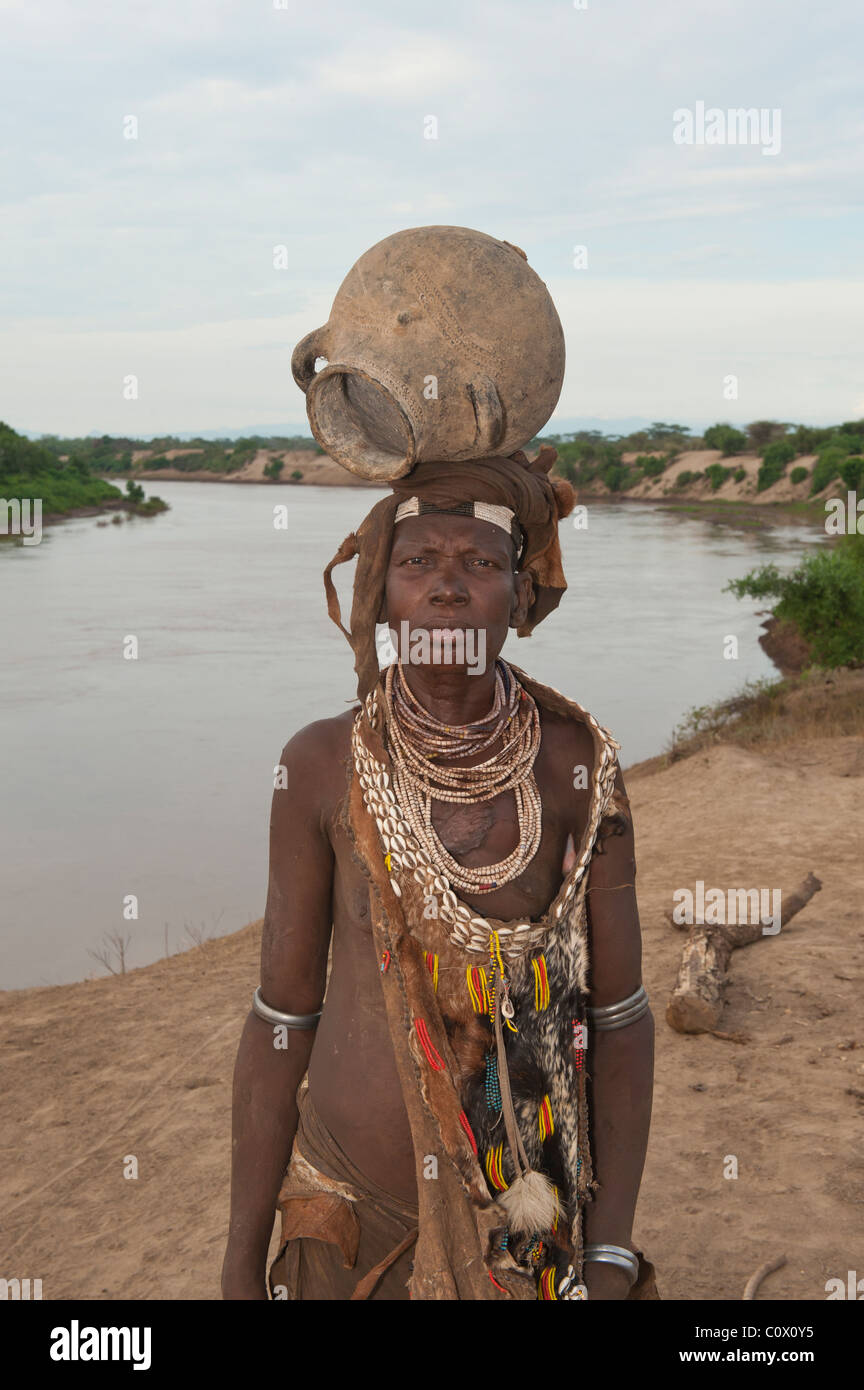 Karo donna con collane fatte di Cowry gusci e un vaso sulla testa, Omo river valley, sud Etiopia Foto Stock