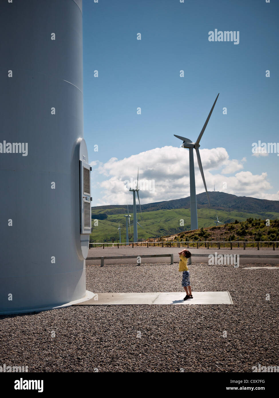 Ragazzo cerca fino a turbina eolica Te Apiti wind farm, Nuova Zelanda. Foto Stock