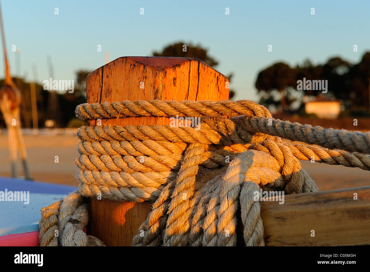 Fissare la fune su una tradizionale barca a vela su di una spiaggia di sabbia con la bassa marea di fronte Mimbeau village, Cap Ferret, Gironde Foto Stock