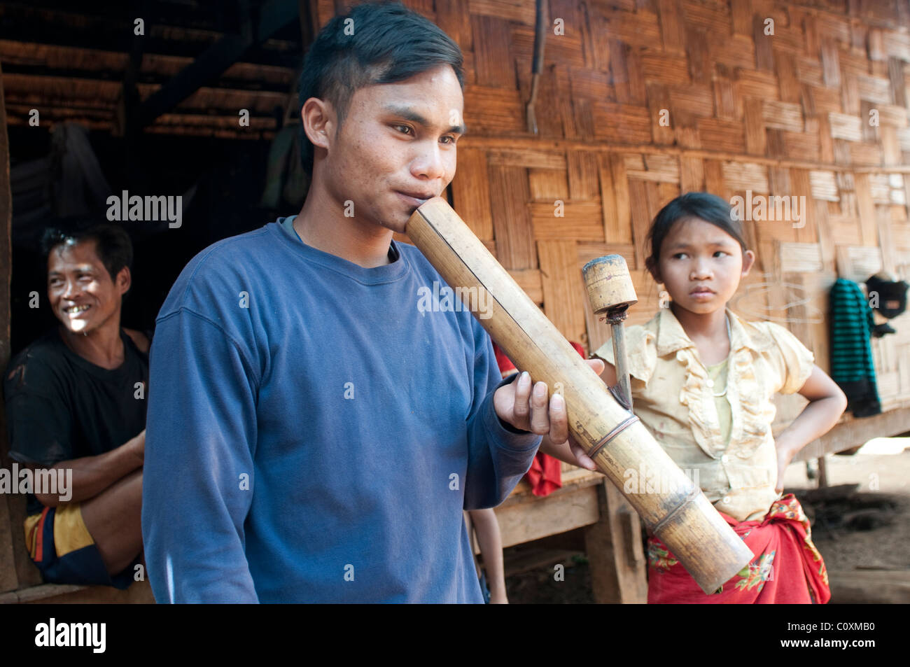 Uomo di fumare tubo di acqua, Hill tribe village, Bolaven Plateau, vicino Pakxe, Laos Foto Stock