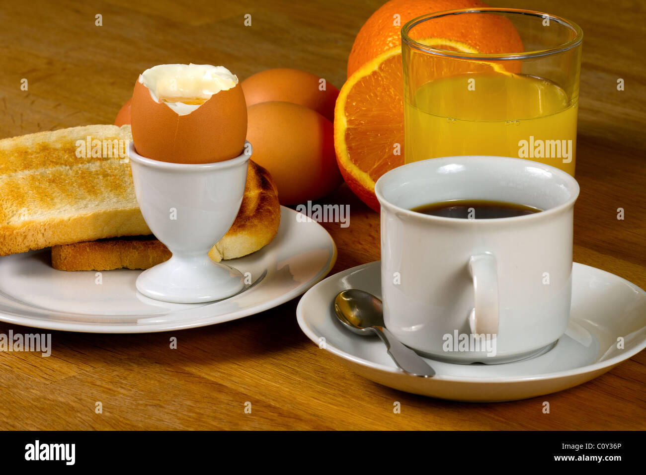 Colazione: uova sode, toast, caffè e succo di frutta fresco. Sul tavolo di legno Foto Stock