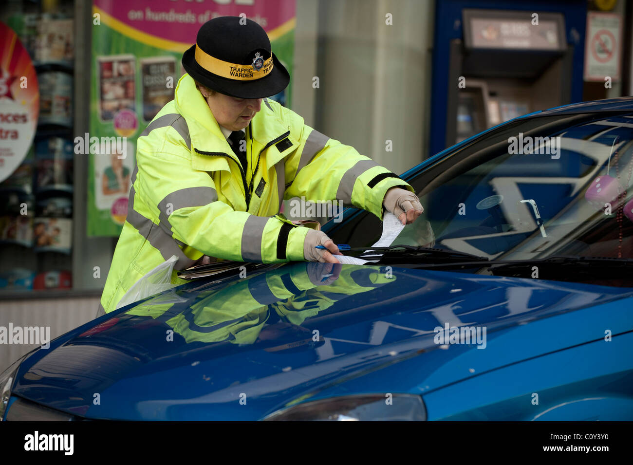 Un vigile che rilascia una penalità fissa i biglietti per il parcheggio, REGNO UNITO Foto Stock