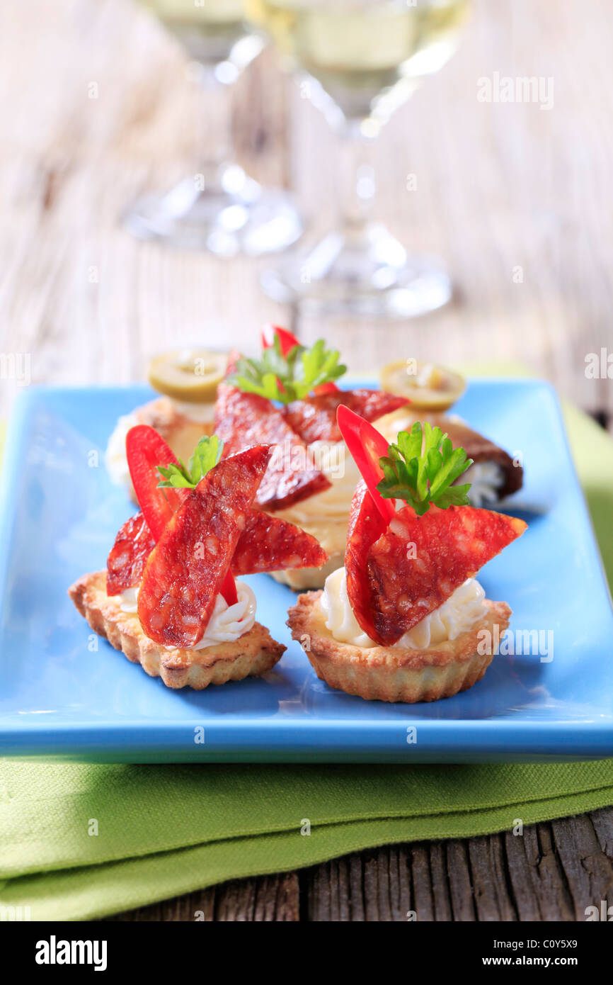 Tartlet basato tartine con pezzi di salame piccante Foto Stock