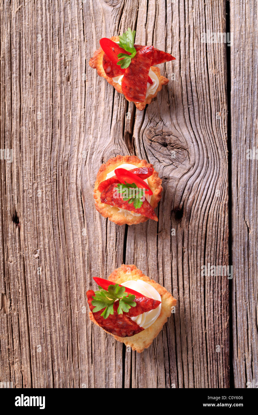 Tartlet basato tartine con pezzi di salame piccante Foto Stock