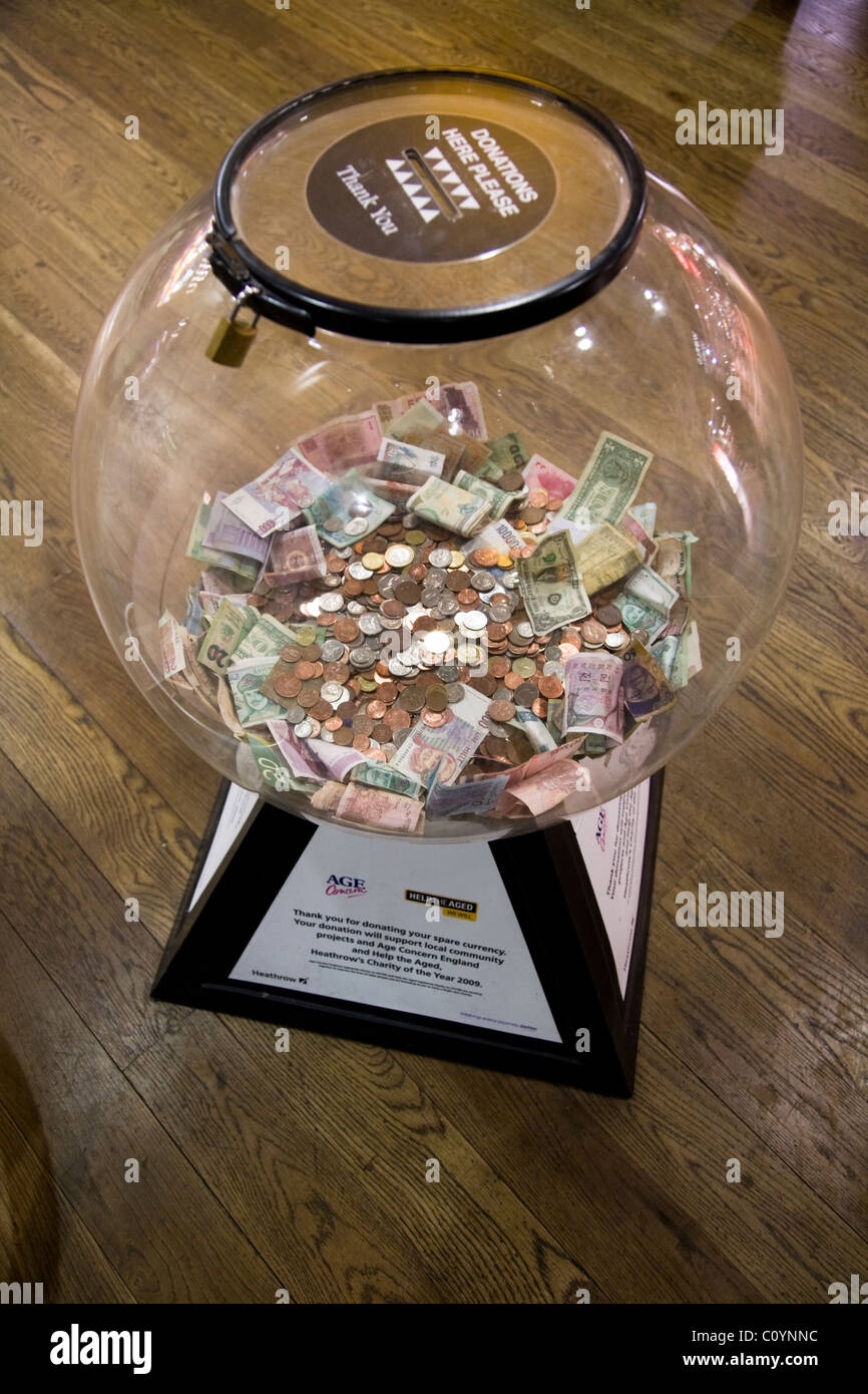 Box collection / raccolta valuta estera / piccola modifica / denaro / Contanti / le monete per la carità. L'aeroporto di Heathrow di Londra. Regno Unito. Foto Stock