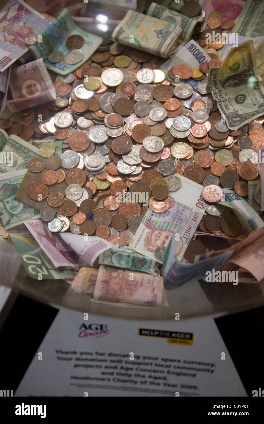 Box collection / raccolta valuta estera / piccola modifica / denaro / Contanti / monete per carità presso l'aeroporto di Heathrow di Londra. Regno Unito. Foto Stock