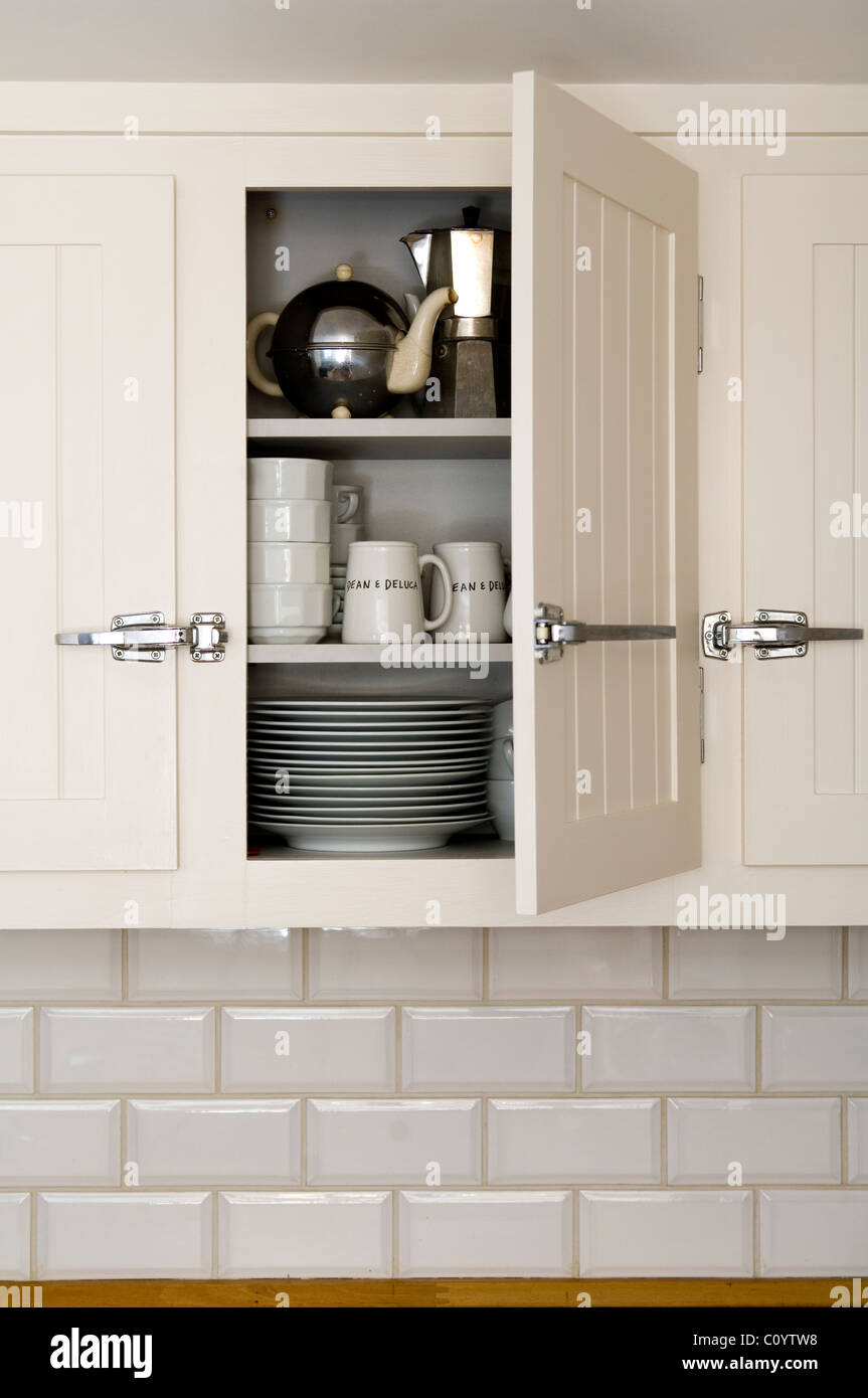 Aprire in legno bianco armadio cucina con stoviglie e cafetiere. Foto Stock