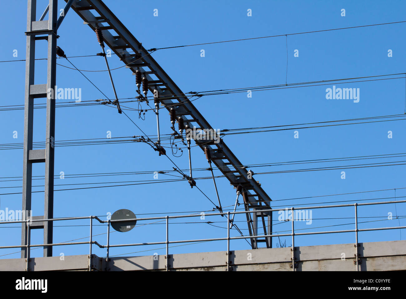 Gantry ferroviaria con i cavi ad alta tensione e gli isolatori sospesi al di sotto. Foto Stock