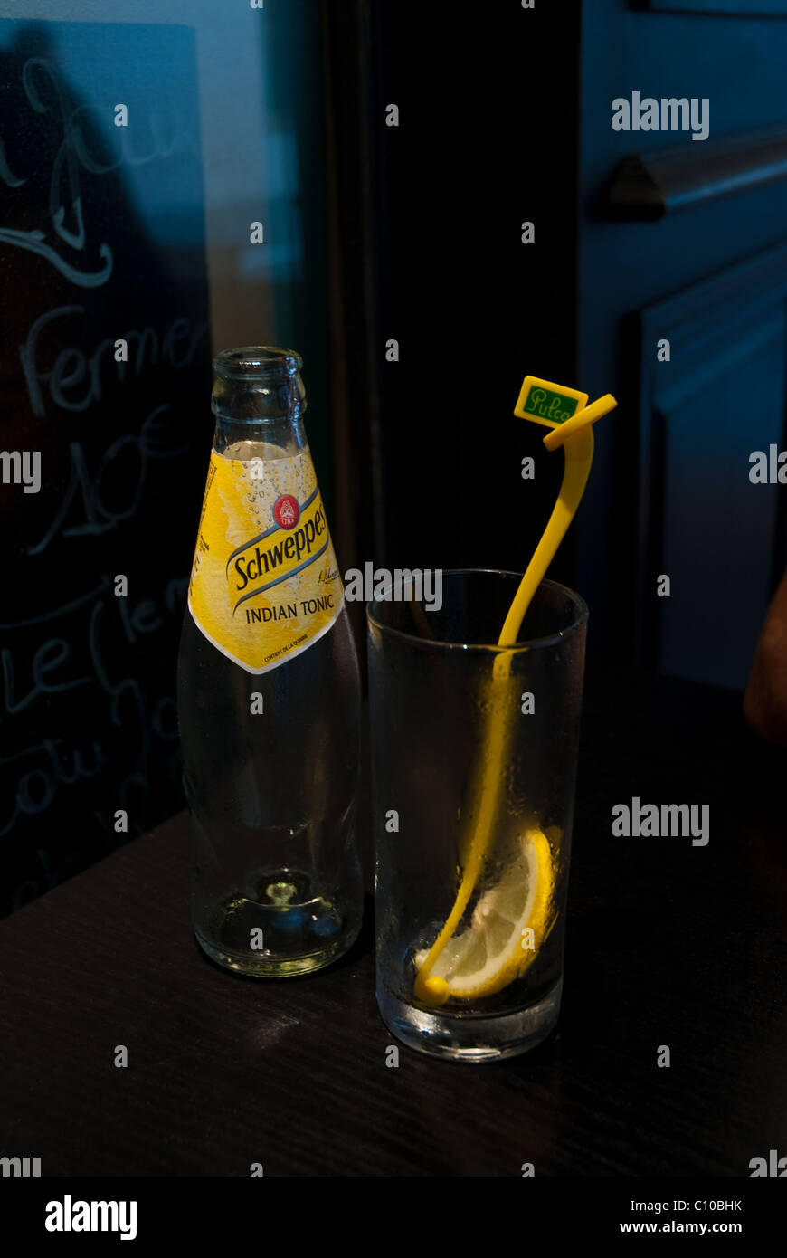 Schweppes Indian tonic bottiglia con vetro, limone e bacchetta di agitazione Foto Stock