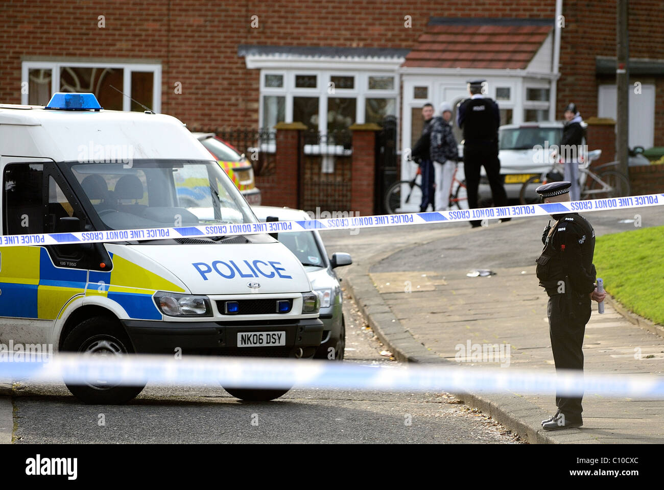 Cordone di polizia intorno a un omicidio in scena a Sunderland Tyne and Wear con auto della polizia e dei furgoni e funzionari di polizia in background Foto Stock