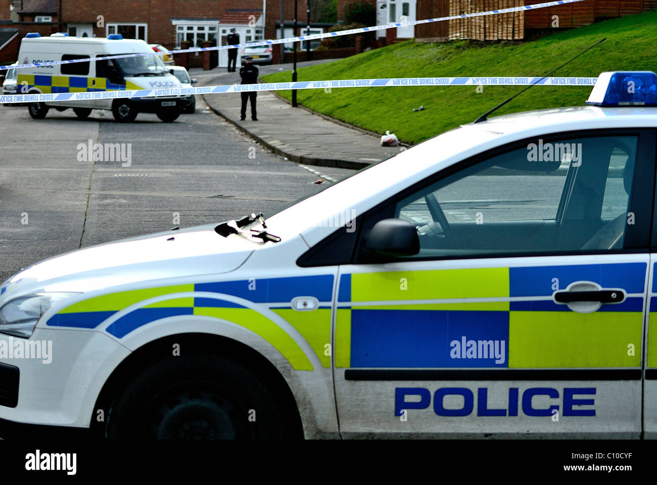 Cordone di polizia intorno a un omicidio in scena a Sunderland Tyne and Wear con auto della polizia e dei furgoni e funzionari di polizia in background Foto Stock