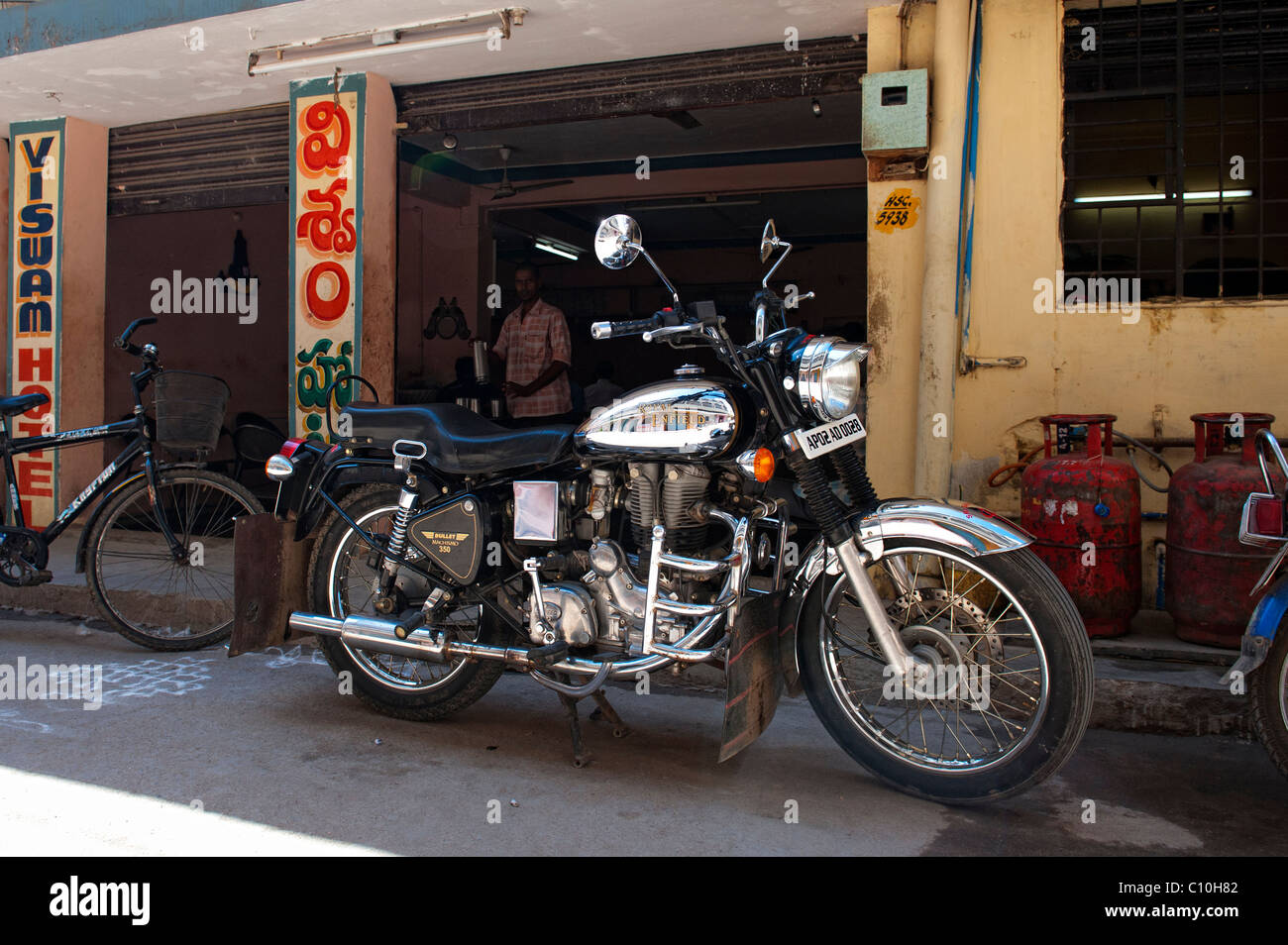 Chrome Royal Enfield 350 bullet motocicletta. Al di fuori di un indiano ristorante Tiffin shop. Puttaparthi, Andhra Pradesh, India Foto Stock