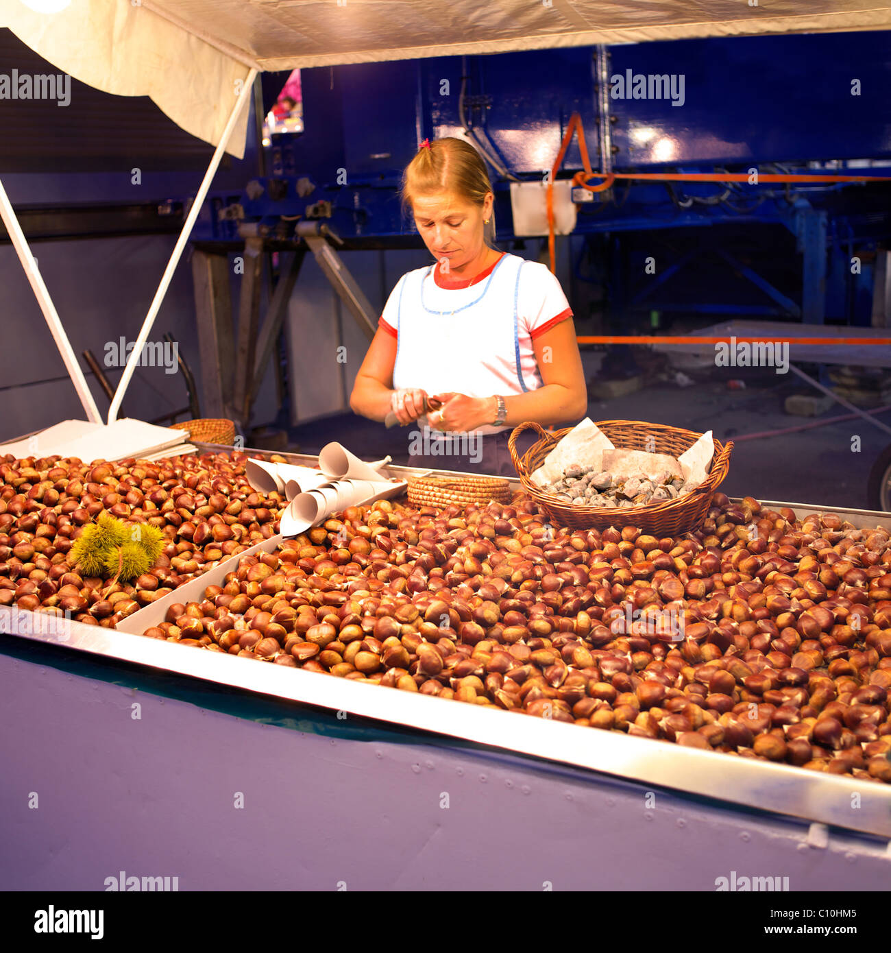 Bionda donna spagnola la vendita di castagne arrostite a Fuengirola Feria, Andalucia, Costa del Sol, Spagna, Europa, arrosto di tostatura Foto Stock