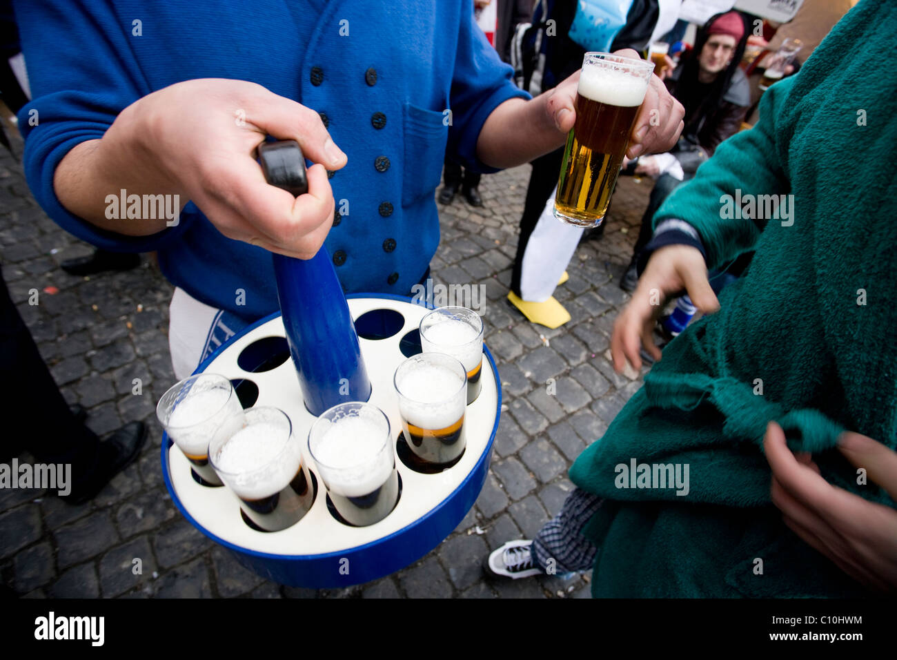 Un Barista serve Kölsch, locar tipica birra, durante il Carnevale Crazy Days a Colonia, in Germania. Foto Stock