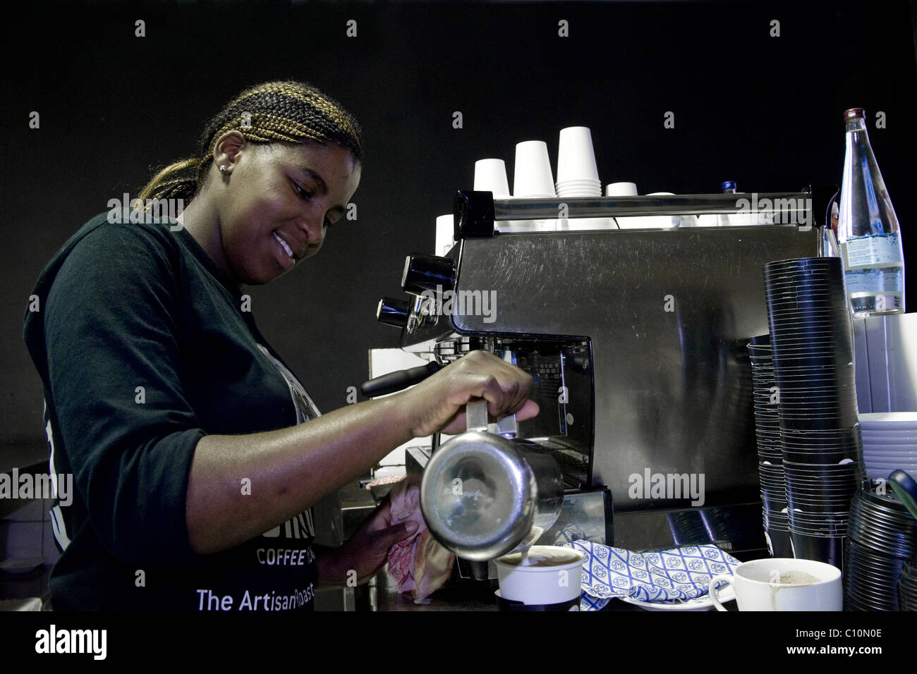 Barista che lavora in una macchina per il caffè in un coffee-house a Città del Capo in Sud Africa Foto Stock