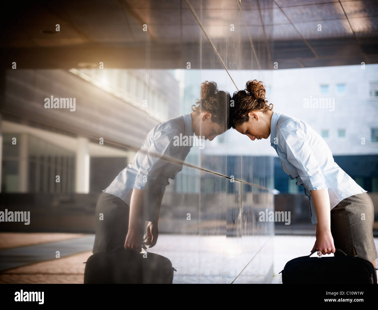 Metà adulto donna italiana sbattendo la testa contro un muro fuori ufficio. Sagoma orizzontale, spazio di copia Foto Stock