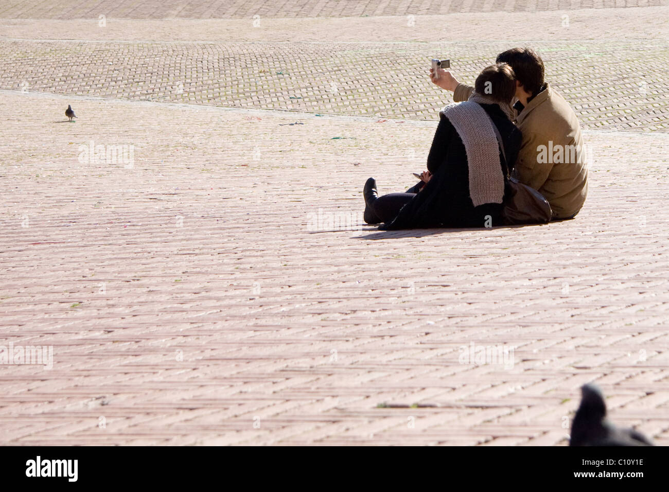 Giovane seduto sul pavimento di prendere essi stessi di una foto Foto Stock