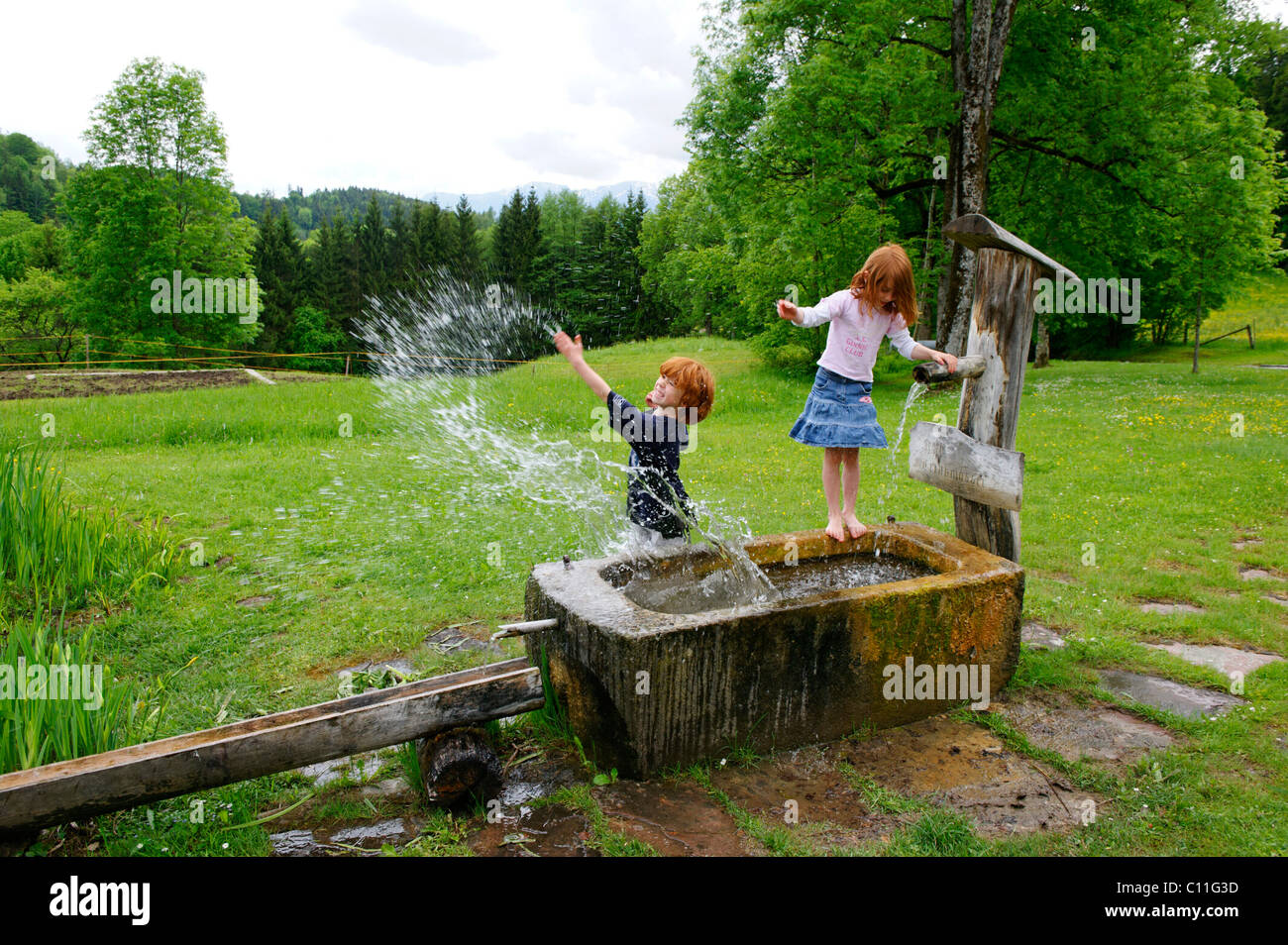 I bambini stanno giocando con acqua a una fontana Foto Stock