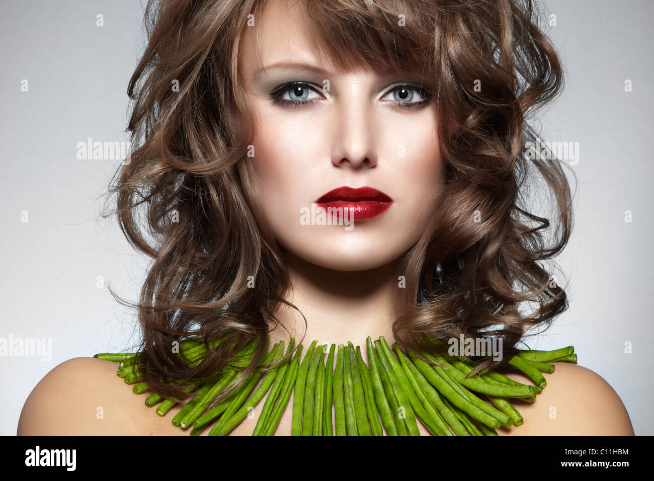 Ritratto di una giovane donna con fagioli verdi come una collana, gioielli Foto Stock