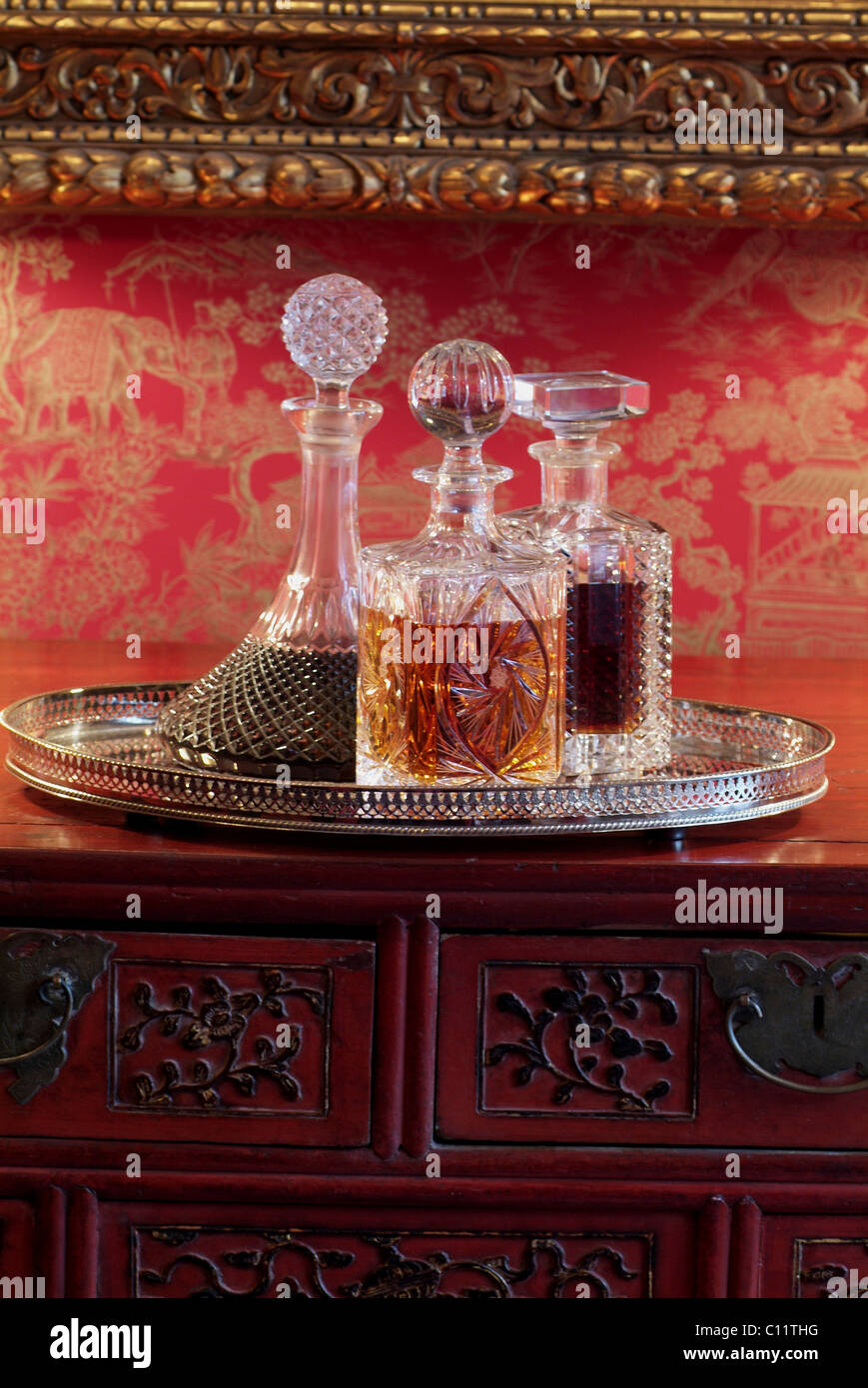 Liquori in un antico edificio di vetro cristallo decantatori su un vassoio  d'argento e un torace asiatica in un ambiente di lusso Foto stock - Alamy