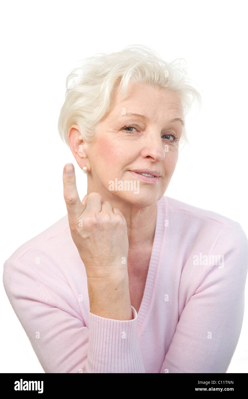 Vecchia donna sollevando il suo dito indice, malizioso Foto Stock