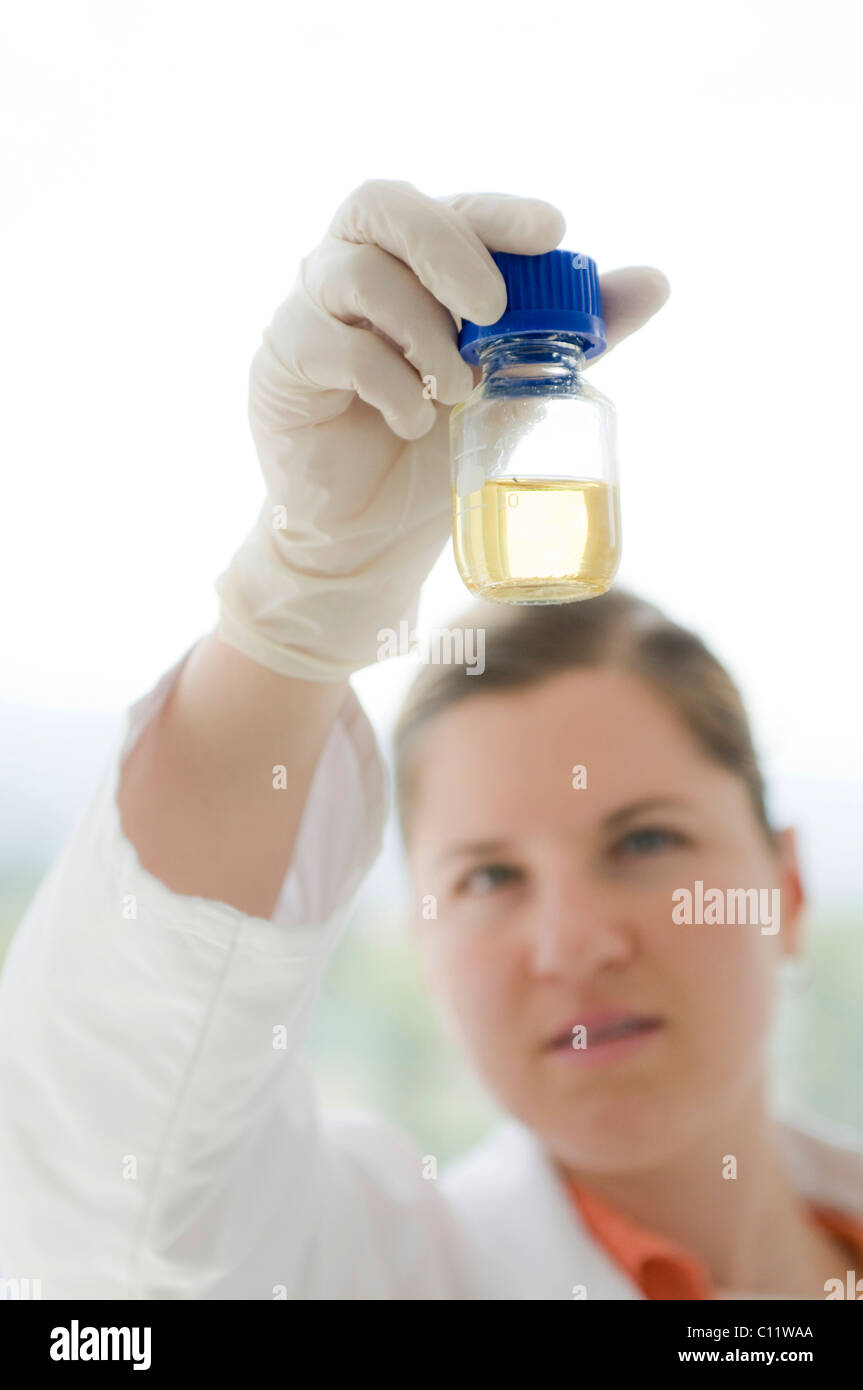 Scienziato tenendo in mano un contenitore in vetro Foto Stock