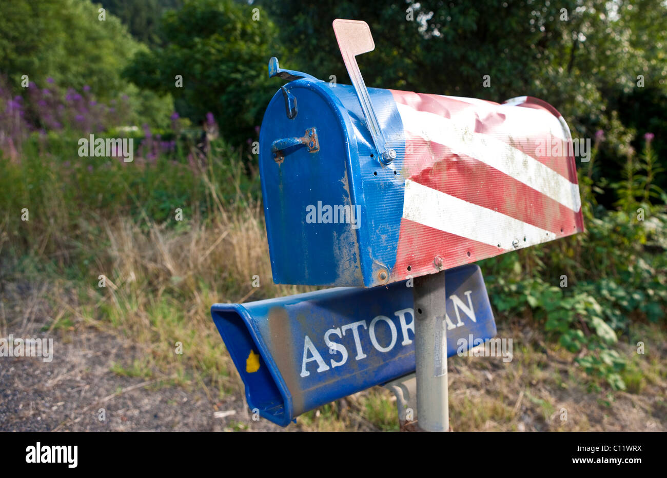 Vecchio ammaccato tipica cassetta postale americana dipinta con la bandiera americana sul ciglio della strada, Oregon, Stati Uniti d'America Foto Stock