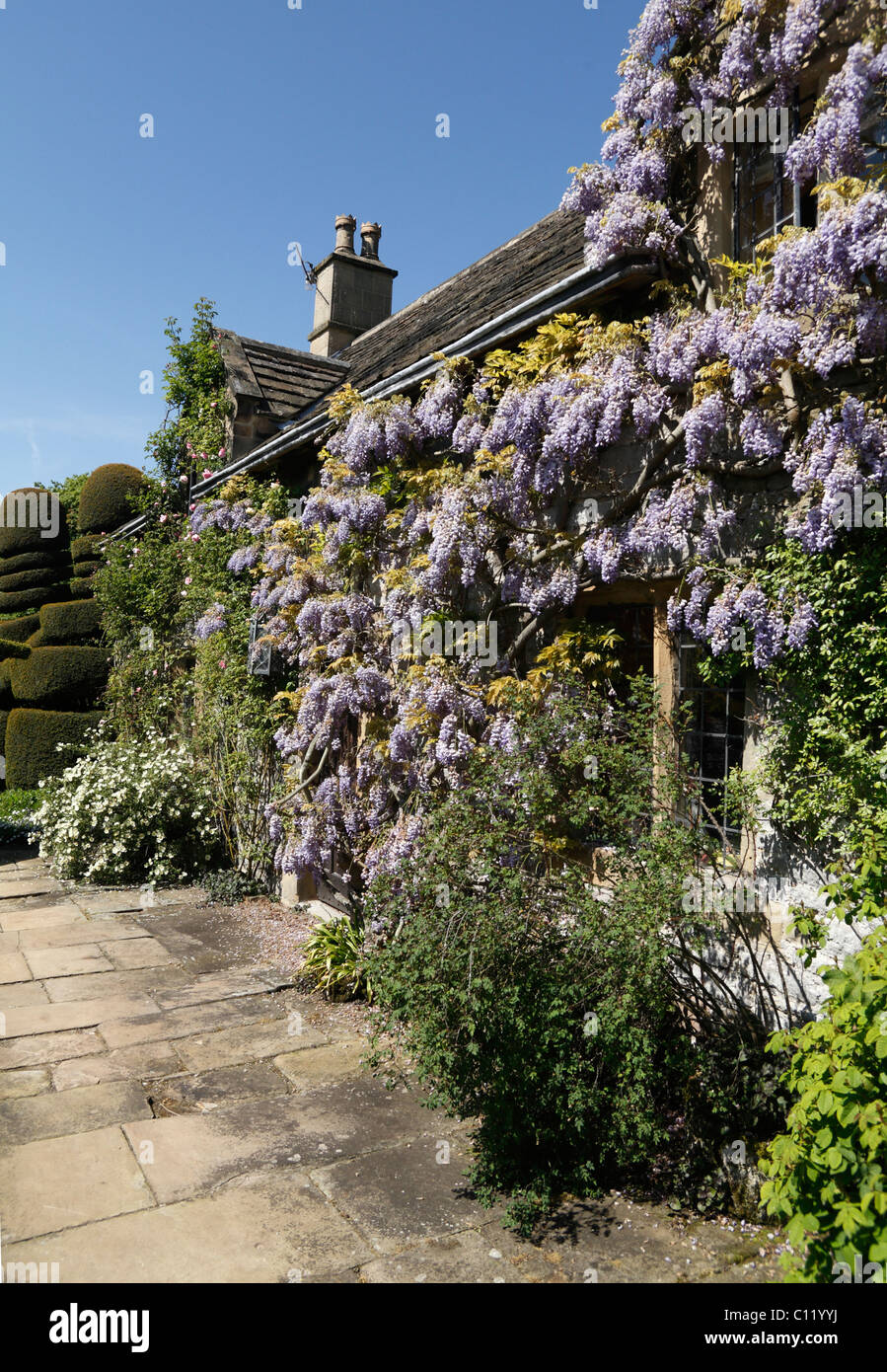 Con il tetto di paglia del giardiniere Cottage con Wisteria sinensis medievale e Tudor House Haddon Hall Bakewell Derbyshire Foto Stock